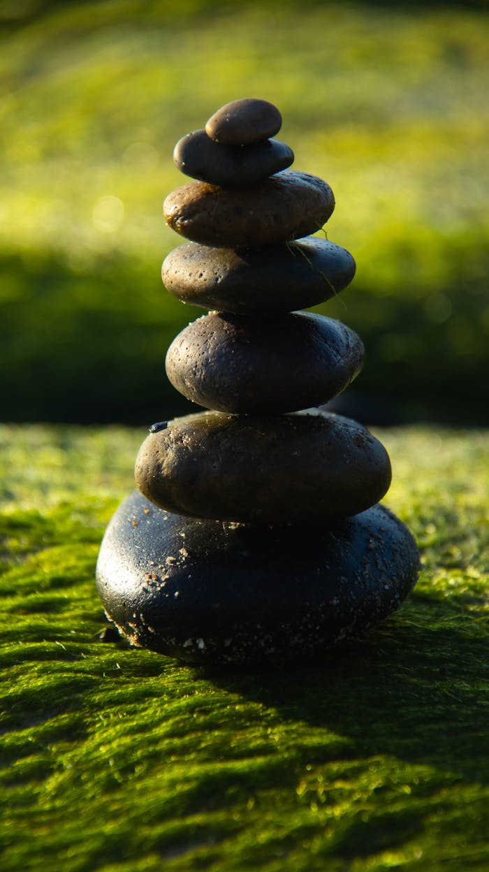 Serene stack of stones on a mossy background, representing balance and tranquility.